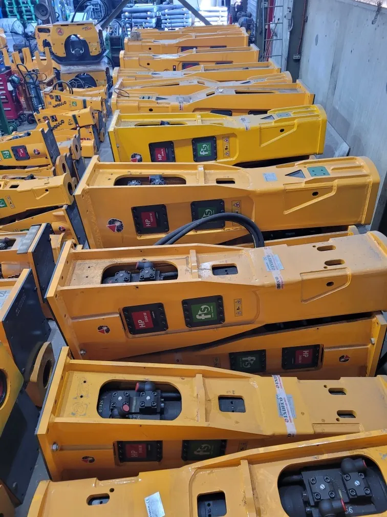 Rows of hydraulic breaker attachments in the JW Hydraulics & Mechanical workshop stock