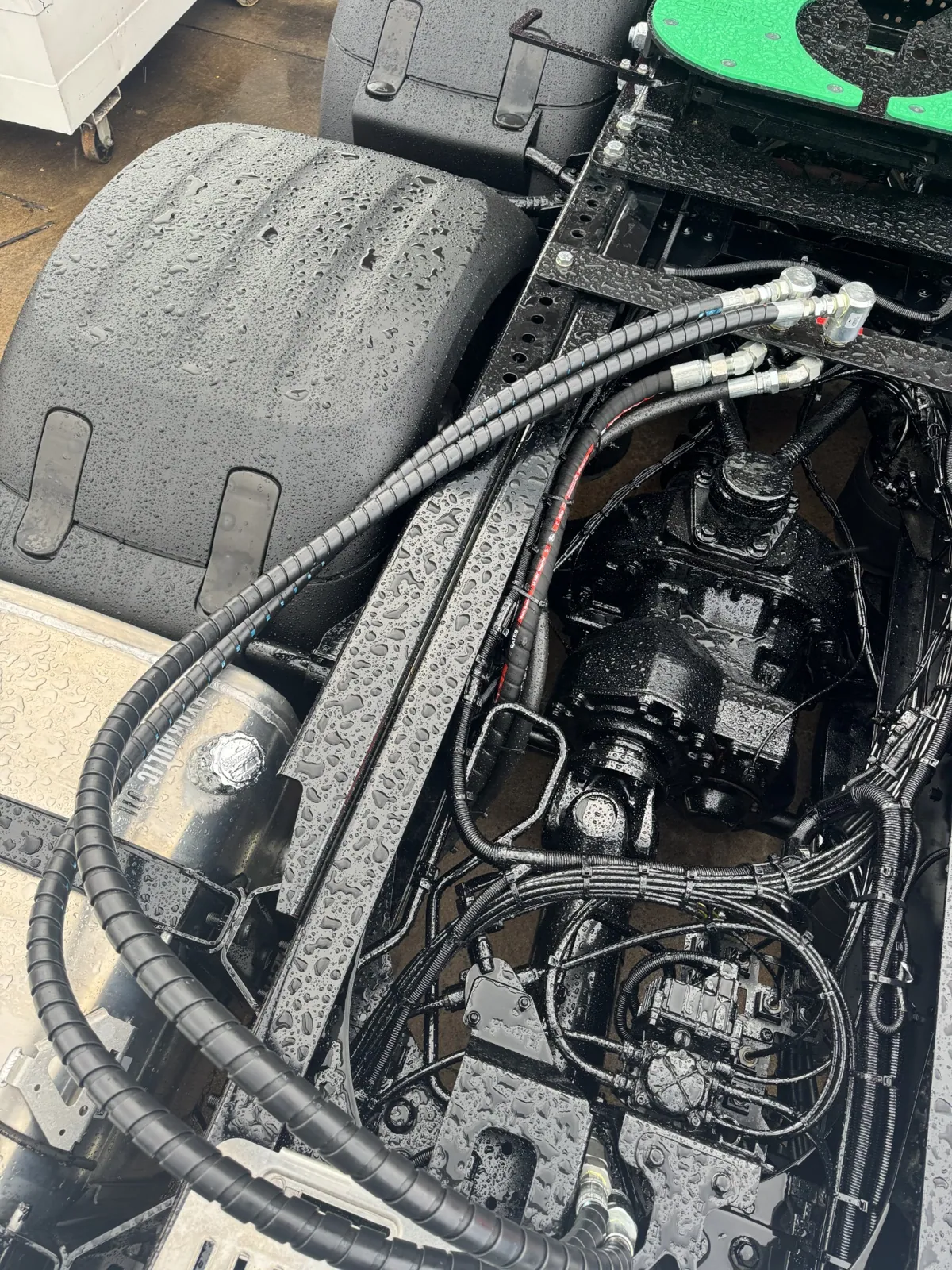 Hydraulic pump and hose assembly inside a machine bay during a hydraulic hose repair