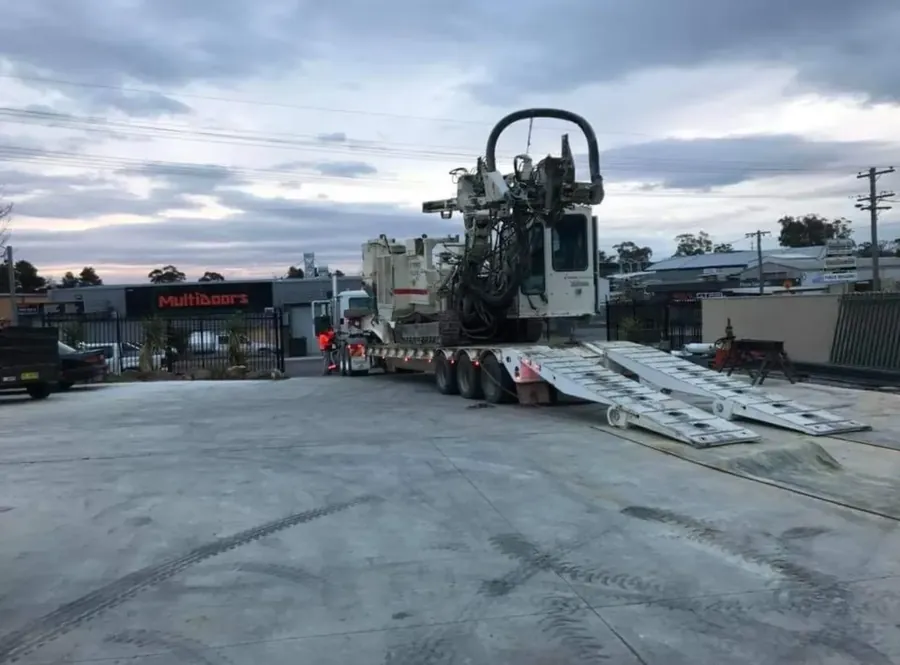 Horizontal directional drilling machine loaded onto a low loader trailer for breakdown recovery