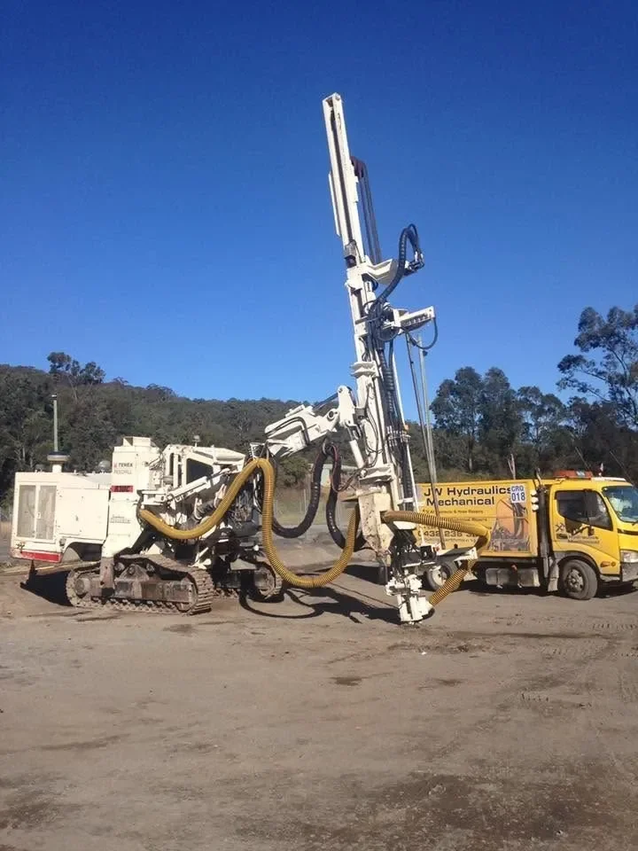 JW Hydraulics & Mechanical service truck beside a track-mounted drill rig on site near Canberra