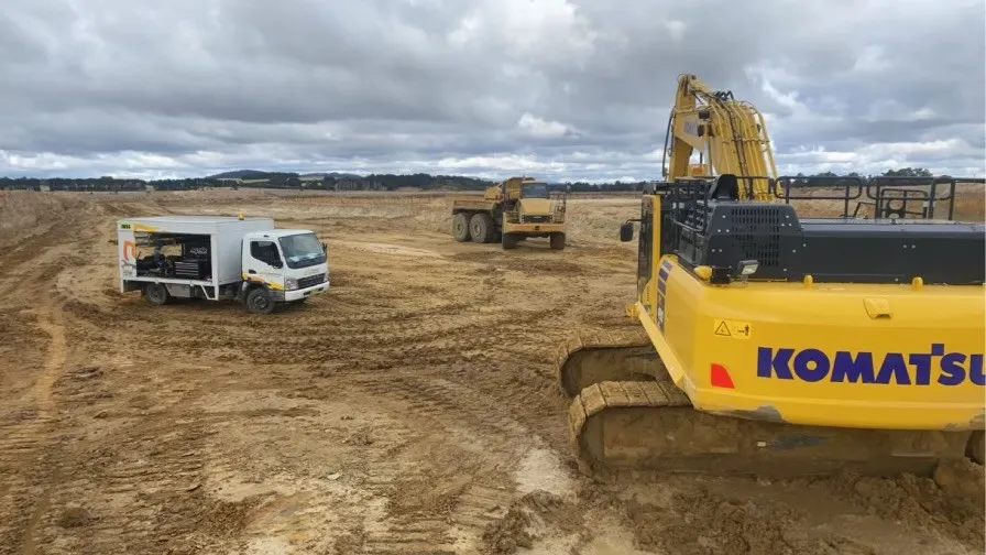 Komatsu excavator and service vehicle on an open earthworks site