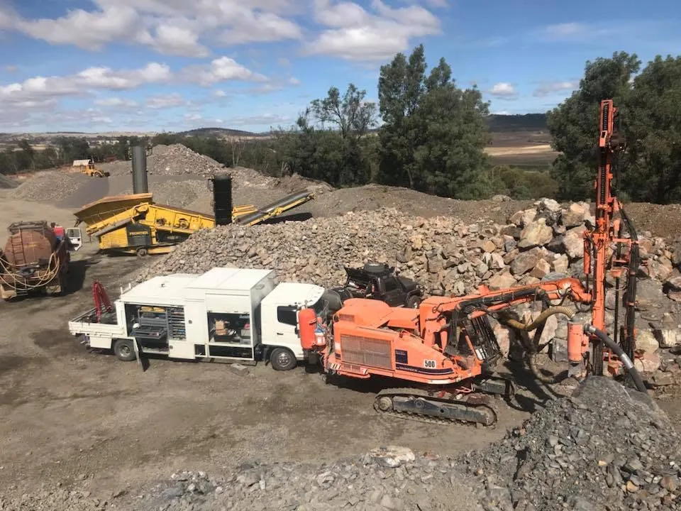 JW Hydraulics & Mechanical service truck beside a tracked drill rig on a quarry site in the Canberra region