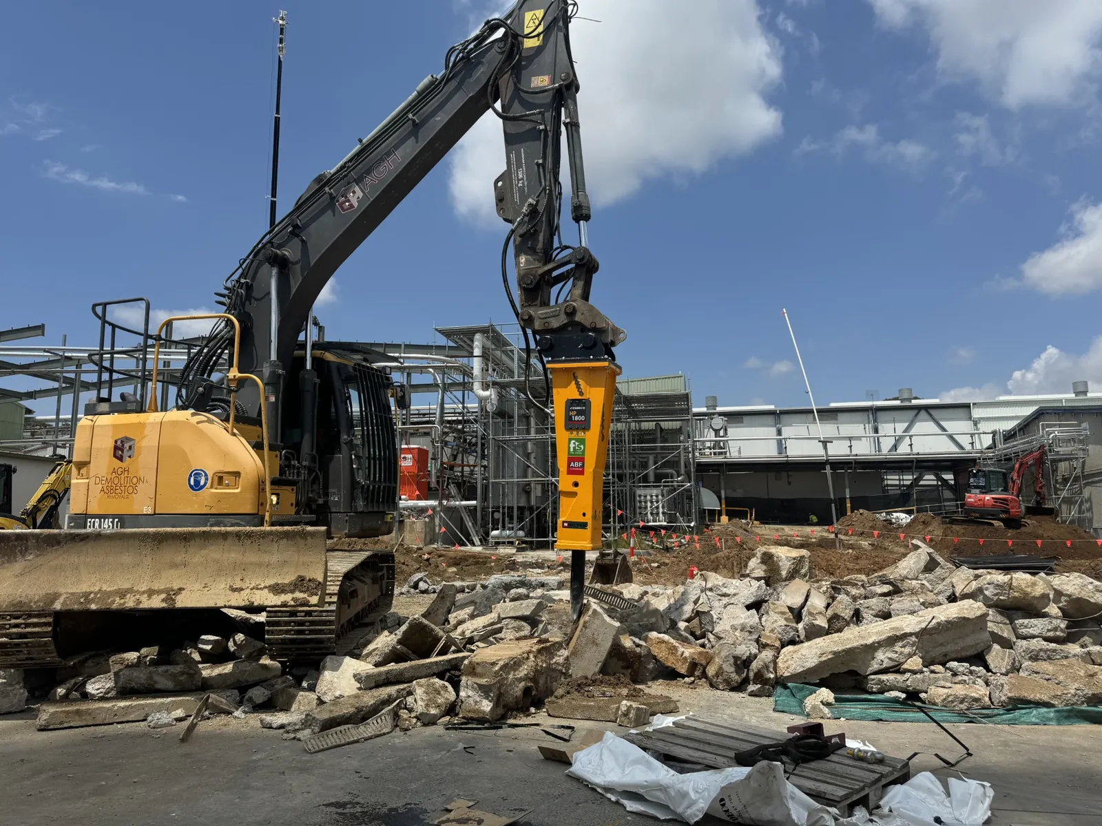 Excavator fitted with a hydraulic breaker attachment on a demolition site near Queanbeyan