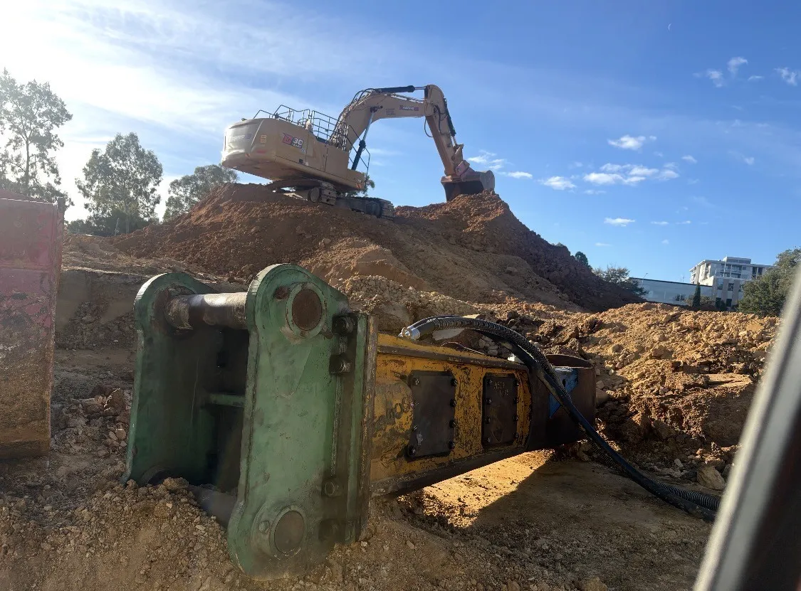 Hydraulic breaker attachment on an excavator site awaiting attachment repairs in Canberra