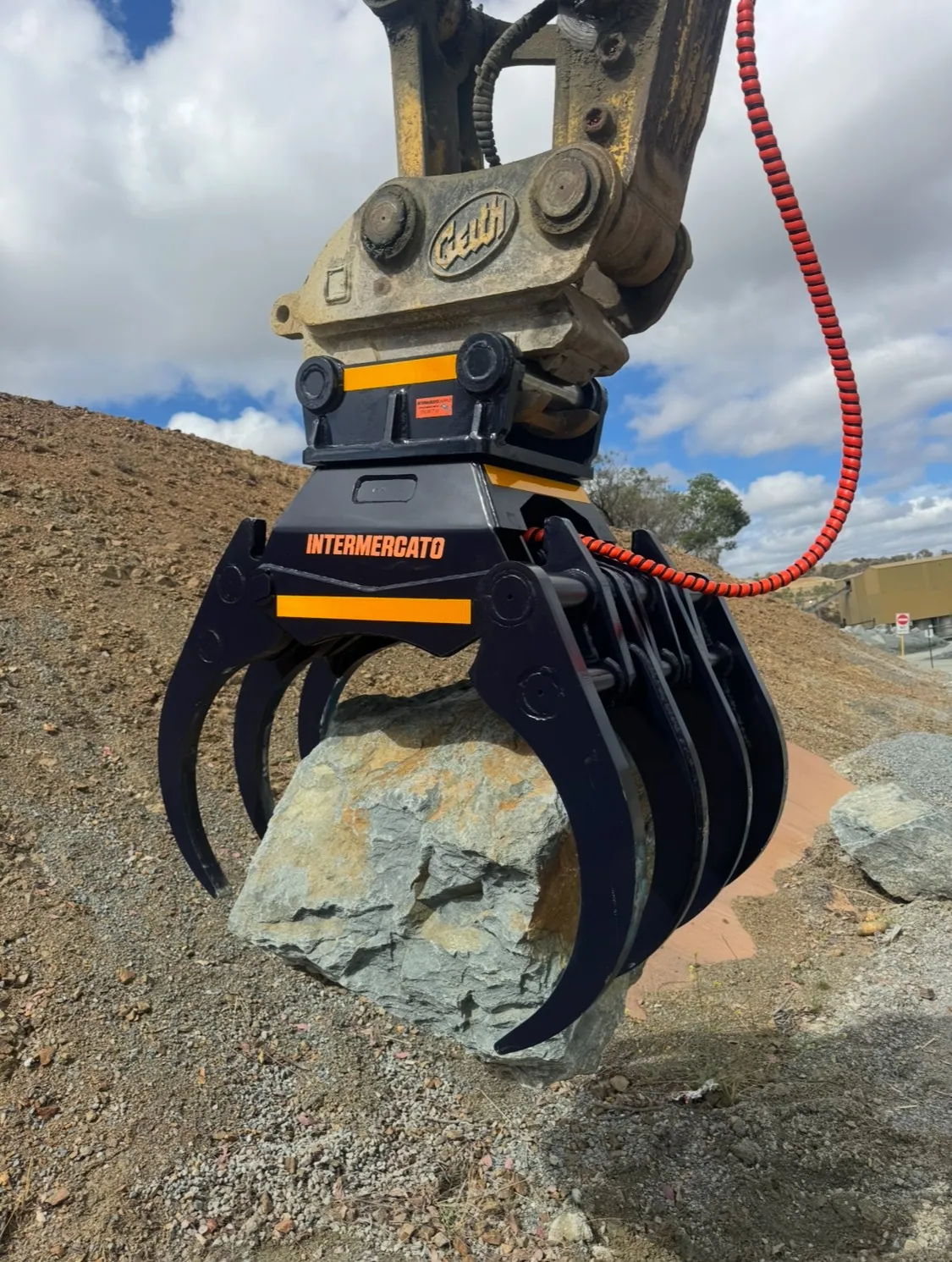 Intermercato grapple attachment gripping a rock on a quarry site after attachment repairs in Canberra