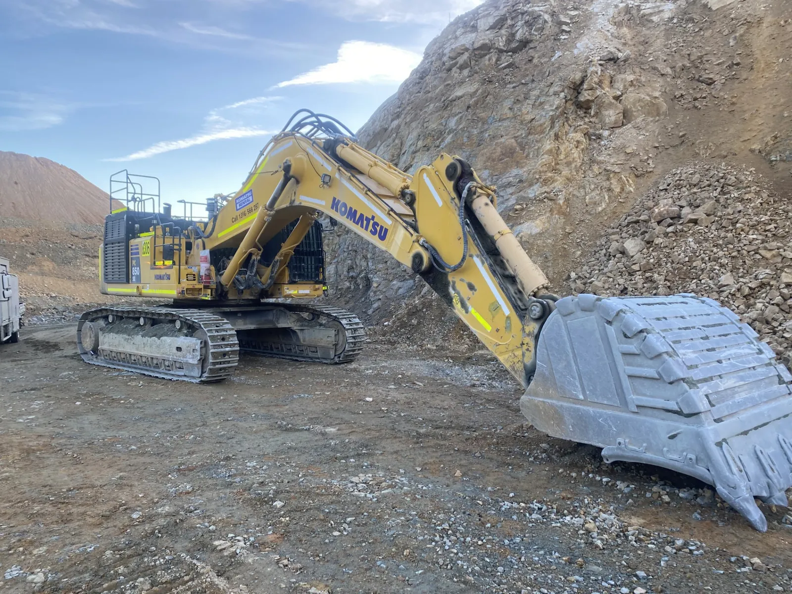 Komatsu excavator with a bucket attachment working in a quarry serviced by JW Hydraulics & Mechanical